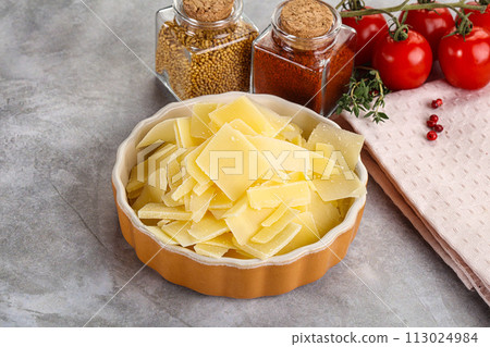 Sliced parmesan cheese in the bowl 113024984