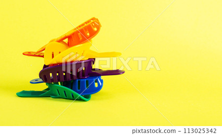 Multi-colored dental spoons for taking an impression of the patient's dental jaw on a yellow background. Manufacturing of crowns and prostheses of the jaw in orthodontics. Copy space for text, Multi-colored dental spoons for taking an impression of the patient's dental jaw on a yellow background. Manufacturing of crowns and prostheses of the jaw in orthodontics. Copy space for text, 113025342
