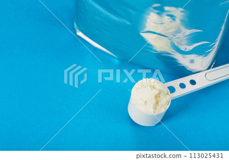 Shiny package with powdered baby milk food on a blue background. Baby formula. Copy space for text Shiny package with powdered baby milk food on a blue background. Baby formula. Copy space for text 113025431