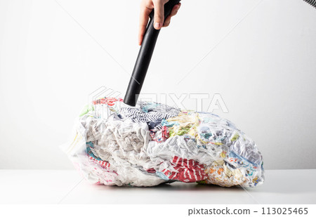 Pumping out air from a vacuum bag with a vacuum cleaner for storing compact-sized items and clothes. Copy space for text Pumping out air from a vacuum bag with a vacuum cleaner for storing compact-sized items and clothes. Copy space for text 113025465