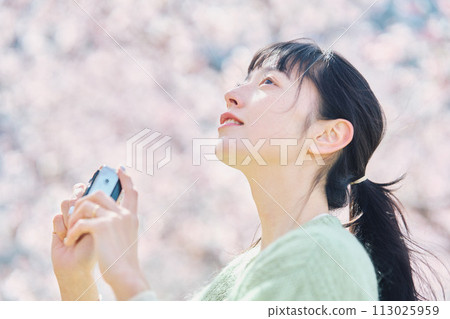 Women taking photos of cherry blossoms 113025959