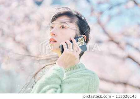 櫻花下用智慧型手機說話的女人 113026143