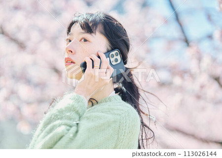 櫻花下用智慧型手機說話的女人 113026144