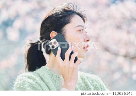 櫻花下用智慧型手機說話的女人 櫻花下用智慧型手機說話的女人 113026145
