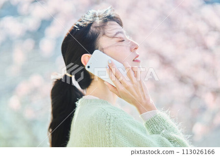 櫻花下用智慧型手機說話的女人 113026166