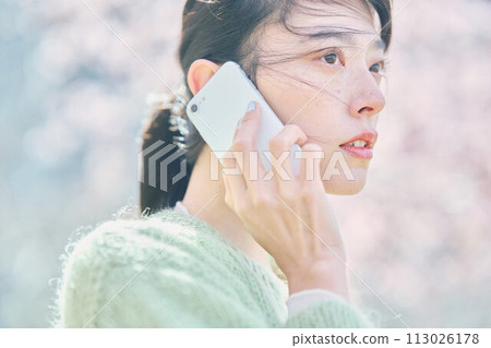 櫻花下用智慧型手機說話的女人 櫻花下用智慧型手機說話的女人 113026178