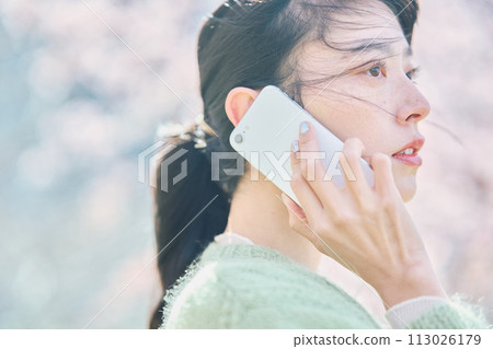 櫻花下用智慧型手機說話的女人 櫻花下用智慧型手機說話的女人 113026179