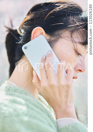 櫻花下用智慧型手機說話的女人 113026180
