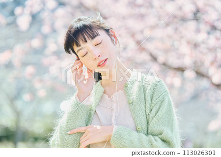 櫻花叢中聽音樂的女人 113026301