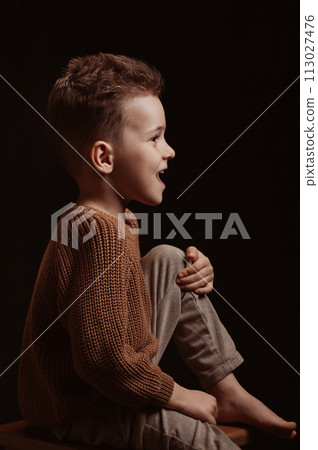Profile portrait of a happy screaming stylish white Caucasian child preschooler kid boy on chair Profile portrait of a happy screaming stylish white Caucasian child preschooler kid boy on chair 113027476