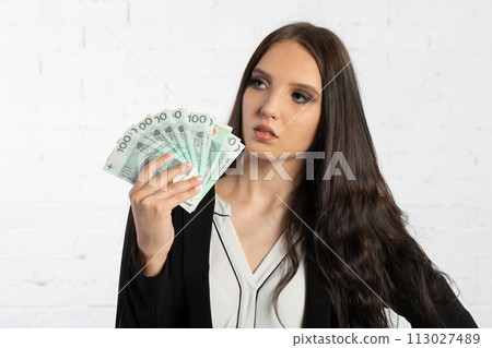 Businesswoman holds Polish banknotes in a fan-shaped hands. Businesswoman holds Polish banknotes in a fan-shaped hands. 113027489