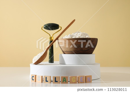 Collagen powder in a wooden bowl with a massage roller 113028011
