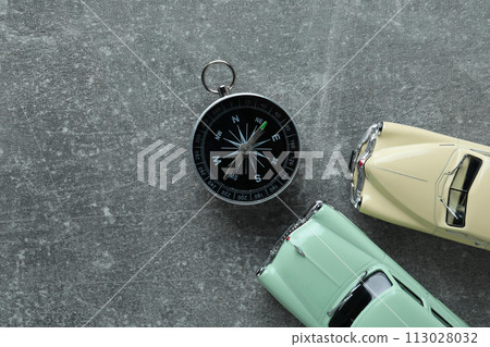 A compass on a table with a car. 113028032