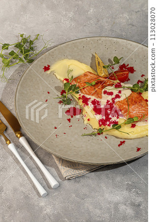 Salmon with mashed potatoes, topped with white sauce and garnished with caviar and pea sprouts. Salmon with mashed potatoes, topped with white sauce and garnished with caviar and pea sprouts. 113028070