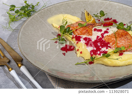 Salmon with mashed potatoes, topped with white sauce and garnished with caviar and pea sprouts. Salmon with mashed potatoes, topped with white sauce and garnished with caviar and pea sprouts. 113028071