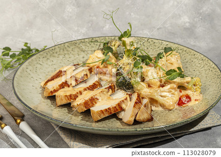 Grilled chicken breast sliced with stewed cauliflower and white sauce. 113028079