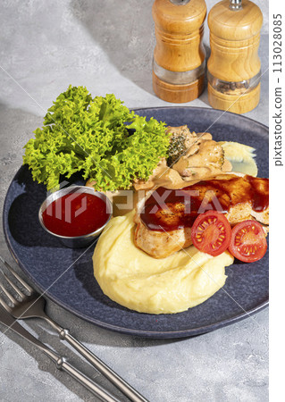 Mashed potatoes with chicken breast in red sauce with lettuce and tomato slices. Mashed potatoes with chicken breast in red sauce with lettuce and tomato slices. 113028085