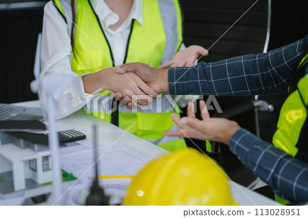architects and engineers shake hands while working for teamwork and cooperation after completing an agreement in an office facility, successful cooperation concept. architects and engineers shake hands while working for teamwork and cooperation after completing an agreement in an office facility, successful cooperation concept. 113028951