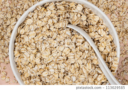 Dry uncooked oat flakes in a plate top view Dry uncooked oat flakes in a plate top view 113029585