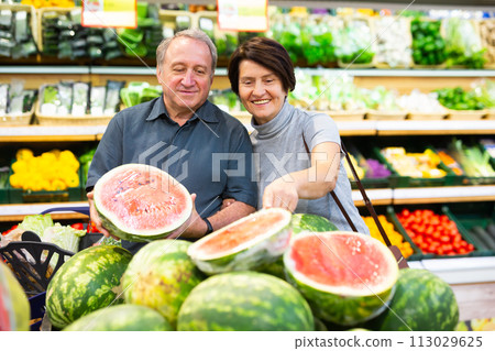 Mature woman and man selecting watermelon in greengrocer 113029625