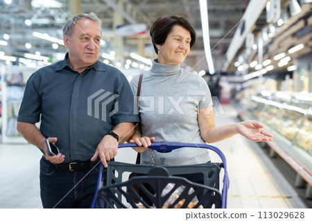 Elderly couple walks through a supermarket 113029628