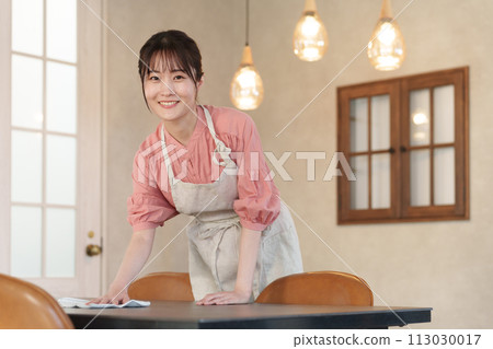 Female part-time staff cleaning tables 113030017