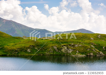 capra lake of fagaras range on a cloudy day. summer nature background in mountain of romania. popular travel destination of transylvania alps capra lake of fagaras range on a cloudy day. summer nature background in mountain of romania. popular travel destination of transylvania alps 113032933