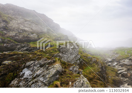 romanian countryside scenery on a foggy day. mountainous nature landscape with steep rocky hills. extreme summer vacations in fagaras romanian countryside scenery on a foggy day. mountainous nature landscape with steep rocky hills. extreme summer vacations in fagaras 113032934