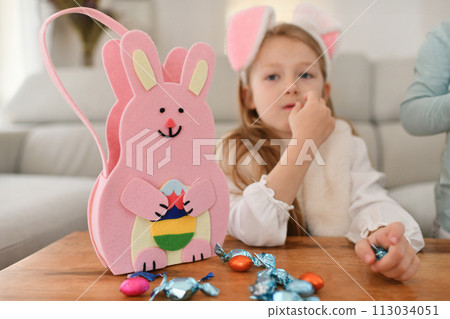 Girl with bunny ears and basket for chocolate eggs Easter Girl with bunny ears and basket for chocolate eggs Easter 113034051