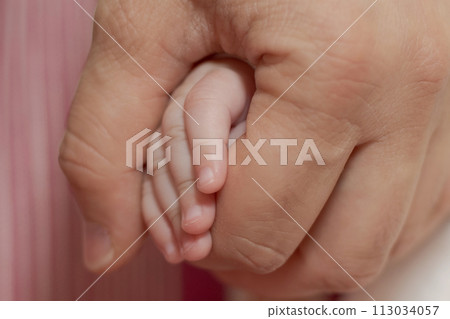 Father holding his newborn daughter's hand Father holding his newborn daughter's hand 113034057