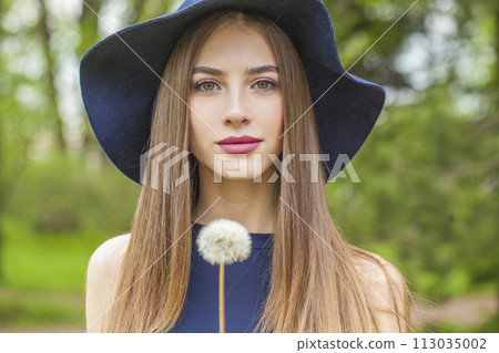 Stylish fashion model with long brown hair and natural makeup against floral background outdoor Stylish fashion model with long brown hair and natural makeup against floral background outdoor 113035002