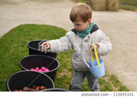 A boy looking for eggs in a bag for Easter 113035101