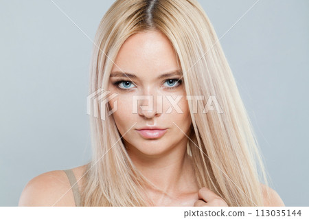 Closeup studio portrait of fashion female model with long blonde hairstyle and shiny fresh skin  113035144