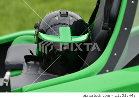 Helmet on a two-seater green gyrocopter at the airfield Helmet on a two-seater green gyrocopter at the airfield 113035442