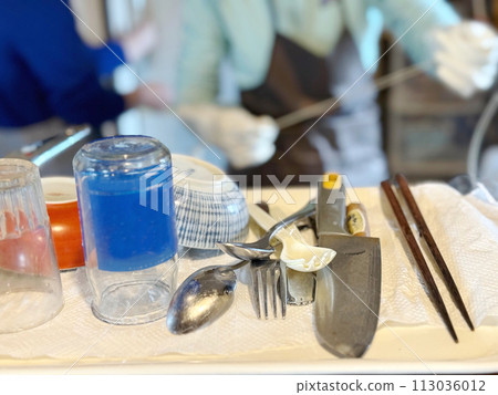 Women cleaning up dishes and knives in a blur 113036012