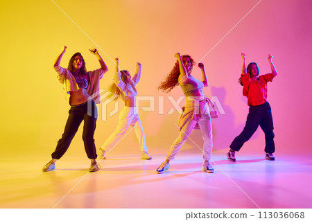 Dynamic image of young people, female dancers in motion dancing modern style dance against gradient background in neon light 113036068