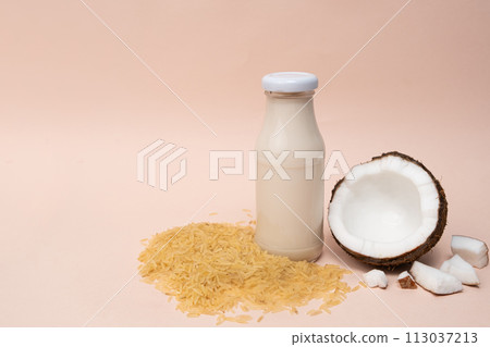 Rice coconut vegan milk in glass bottles on beige background, copy space for text 113037213