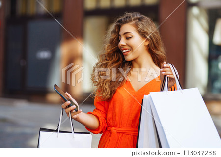 Happy tourist doing shopping using smartphone while walking in sunny city Shopping lifestyle concept 113037238