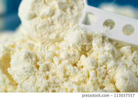 Measuring spoon in a plate with dry baby food for preparing infant formula. Enriched with bifidobacteria, minerals and vitamins, macro 113037557