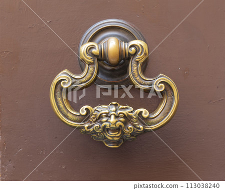 Vintage brass door knocker with face. 113038240