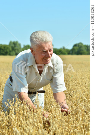 Portrait of senior man resting in field Portrait of senior man resting in field 113038262