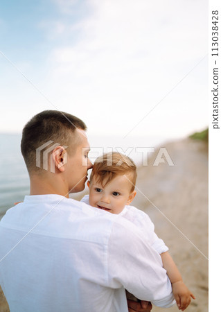 Cheerful young family with little baby boy spending time together on the beach. 113038428