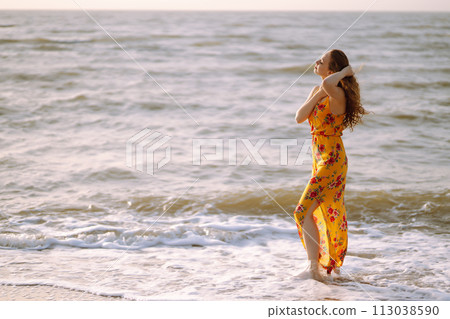 Stylish woman in elegant dress posing near the sea. Summer time. Travel, weekend, relax. Stylish woman in elegant dress posing near the sea. Summer time. Travel, weekend, relax. 113038590