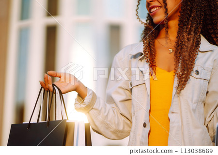 Young woman with shopping bags walking on street. Sale, shopping and happy people concept. Young woman with shopping bags walking on street. Sale, shopping and happy people concept. 113038689
