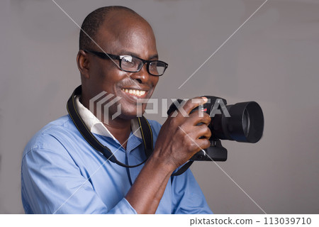 close-up of an adult african man and camera. close-up of an adult african man and camera. 113039710