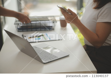 Young adult happy smiling Hispanic Asian student wearing headphones talking on online chat meeting using laptop in university campus or at virtual office. College female student learning remotely. 113040137