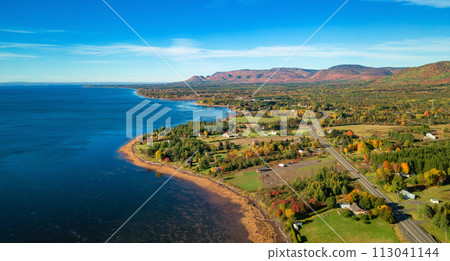 Vibrant landscape on the East Coast of Atlantic Ocean. with road and town. Sunrise Vibrant landscape on the East Coast of Atlantic Ocean. with road and town. Sunrise 113041144