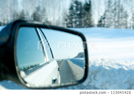 view from the car window onto the snowy road. Winter travel on northern roads view from the car window onto the snowy road. Winter travel on northern roads 113041428
