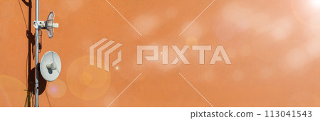 Two telecommunications antennas used for cellular network and wireless Internet, fixed on the building wall. Receiving and digitizing multiple pieces of information at once. Panoramic frame. Bokeh 113041543