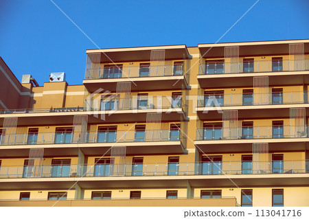 A high multi-family apartment block against a blue sky. A high multi-family apartment block against a blue sky. 113041716